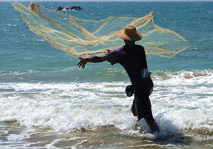 Fischer wirft sein Netz aus